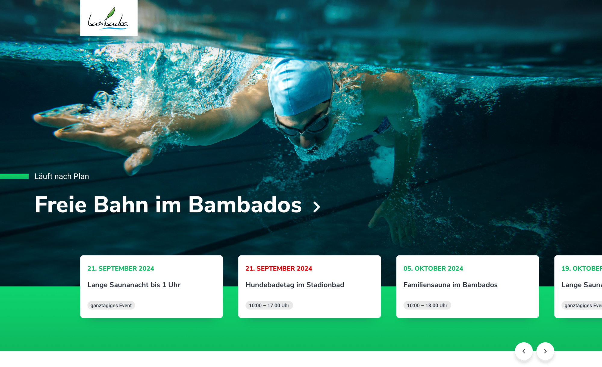 Schwimmer in blauer Badekappe taucht im klaren Wasser des Bambados Schwimmbads unter, dynamisch und konzentriert.